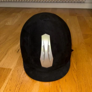 Ridhjälm CRW - En svart ridhjälm från CRW i sammet, den är i väldigt fint skick och knappt använd. Hjälmen har en liten skärm och en bekväm passform. Den är i storlek M (56-58). Justerbar baktill.💕