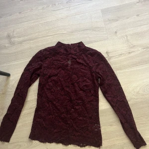 Vinröd spetstopp  - Vinröd spetstopp med knäppning bak. Storlek xs från kappahl