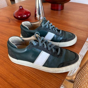 Gröna sneakers från Axel Arigato - Gröna sneakers, bra skick i skorna generellt med mindre skav på nåt ställe.