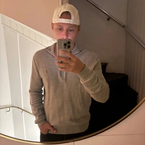 Grå half zip tröja Polo Ralph Lauren - Säljer en stilren grå tröja från Polo Ralph Lauren i mjuk pima bomull. Tröjan har half zip-dragkedja, lång ärm och klassisk broderad logga på bröstet. Perfekt för lager-på-lager och chill vardagsstil.