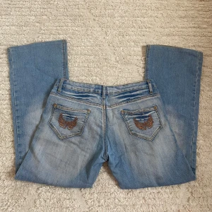 Blå jeans med broderi och nitar - Säljer ett par ljusblå jeans från JOYX!🩷🩷Midjemått (högtmått) rakt över: 40 cm, innerbenslängd: 72 cm