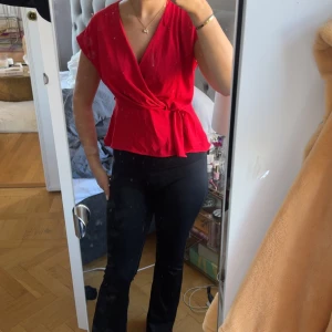 Röd omlottopp med knyt i midjan - Säljer en snygg röd omlottopp med v-ringning och knyt i midjan från zara. Perfekt för fest eller finare tillfällen.❤️😍toppen har endast blivit använd någon fåtal gång