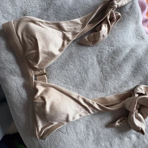 Champagnefärgad bikinitopp - Superfin champagne färgad bikinitopp från HM. Endast använd en gång. Inlägg finns i. Rosetterna på banden går att knyta och och knyta hur man vill. Alla lappar är bortklippta men skulle säga XS.