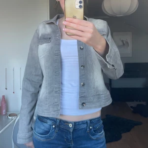 Grå jeansjacka  - Säljer en snygg grå jeansjacka från Wearhouse. Jackan har knappar framtill och långa ärmar. Strl L men liten i storlek, jag har vanligtvis S/M.