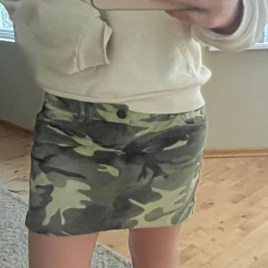 Camoflauge mini kjol - Säljer en grön camo mini kjol med klassiskt camouflage-mönster. Kjolen har fickor både fram och bak samt hällor för bälte. Perfekt för sommaren och i nyskick, hör av er vid frågor❤️