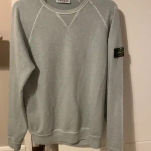 Ljusgrön sweatshirt från Stone Island - Säljer en ljusgrön sweatshirt från Stone Island med klassisk patch på vänster ärm. Tröjan har rund halsringning och långa ärmar. Perfekt för en avslappnad och stilren look. Kvitto finns även. Köptes på nk. Nypris är 2149.  Skriv för fler funderingar eller frågor💯💯💯tröjan är aldrig använd. 