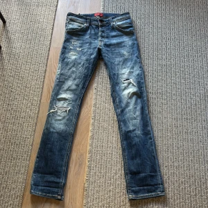 Blå slim fit jeans från Jack & Jones - Säljer ett par blå slim fit jeans med slitningar från Jack & Jones, modell Glenn. W29 L32! hör av er vid minsta fråga eller intresse😊