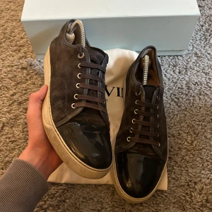 Lanvin Cap Toe skor - Säljer nu dessa riktigt feta grå Lanvins i ett mycket bra skick i uk 9 vilket motsvarar storlek 43 för 1999.  Tyvärr ingår ej tillbehören som ingår på bild inte, utan endast skorna. Det finns en skada på sulan, något som inte borde påverka funktionen. Vid frågor och funderingar är det bara att höra av sig!