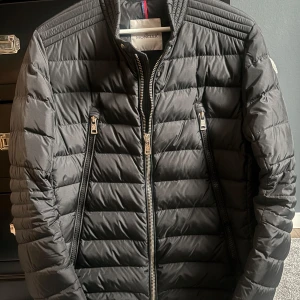 Moncler jacka  - Hej, Säljer en Moncler Amiot Down Biker jacka i toppskick. Den har endast använts vid fyra tillfällen och är i princip som ny. Modellen är både stilren och snygg.  Storlek Medium. Jackan är köpt av en vän och kvitto medföljer därför inte Det finns även en tag på jackan som går att scanna för äkthetsverifiering. För mer frågor kontakta mig gärna mvh Max!