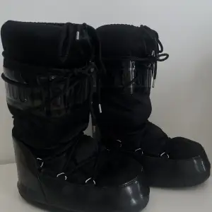 Svarta Moon boots med blancka svarta detaljer! Skorna är super sköna när det är snö och lätta. Har använt dom mycket så dom är formade efter foten på insidan. Men utsidan ser dom som nya ut.💗