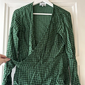 Ganni omlott blus - Säljer denna snygga som tyvärr bara hänger i garderoben och skrynklar. Storlek L men passar mig som är en M.  Knyts med omlottband. 