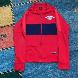 Nike RB Leipzeig tröja - Detta är en RB Leipzeig träningströja av märket Nike, köpt i RB leipzeigs egna fanshop i Tyskland. Påsen till samt kvitto medkommer