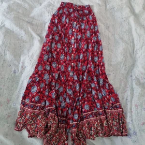 Lång blommig kjol - Mjukt tyg och kjolen delar sig i knähöjd. Den är fullång på mig som är 163 cm. Stretchig midja.