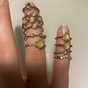 Blandade ringar - 13 stycken blandade ringar med stenar i olika färger. Ringarna är i olika storlekar och passar till alla fingrar, de flesta kommer från ett kit i storlek s/m. (Inget är äkta). Frakt tillkommer!!!!!