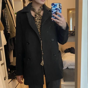 Grå kappa - Mörkgrå kappa i ull, riktigt varm. Obs, spegeln är smutsig och inte plagget.