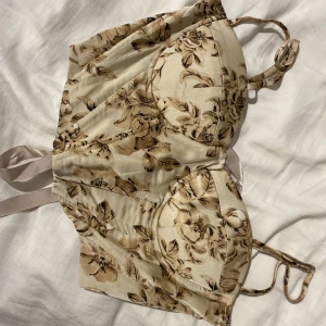 Korsett - Fin korsettopp med blommor på. Knytning bak och justerbara axelband. Vadderad byst och insydda ”pinnar” framtill. Från shein men är fint sydd och har inga defekter. Frakt tillkommer