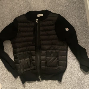 Moncler Cardigan - Lägger upp igen då jag glömde lösen till mitt andra konto! Säljer min moncler cardigan i storlek 2. Säljer den då den är lite tight på mig som är M/L. Jätte bra skick o kan skicka flera bilder💕💞💖VILL INTE BYTA