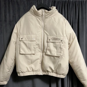 Puffer jacket - Krämvit/ljusbeige puffer jacket från PrettyLittleThing. Aldrig använd så i väldigt gott och fint skick. Jackan är i storlek XL men den passar även mig som brukar ha storlek S om man inte vill ha jackan så tajt. Köparen står för frakten. Swish. 