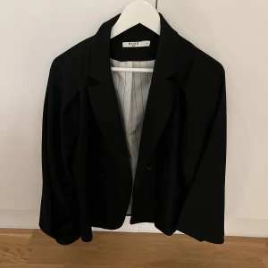 Kavaj - Svart kavaj från NAKD. Ballongärmad. Använd fåtal gånger. (Det är spegeln som är smutsig inte kavajen). 