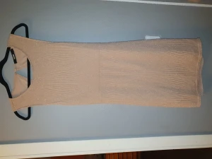Partydress - Glittrig klänning i rosabeige färg. Öppen i ryggen. Knälång