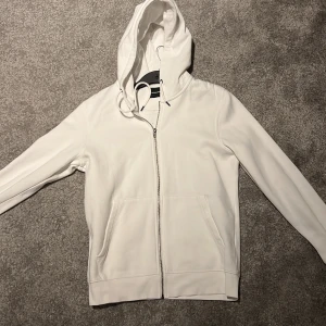 Vit Zip Hoodie - Vit zip hoodie ifrån Jack & Jones storlek M. 9/10 skick. Använd fåtal gånger. Nypris 500kr