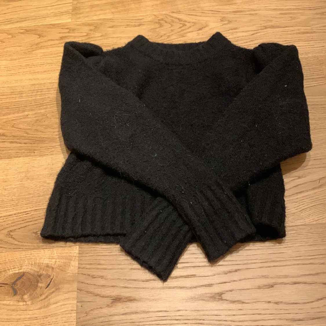 Svart, stickad tröjađ€