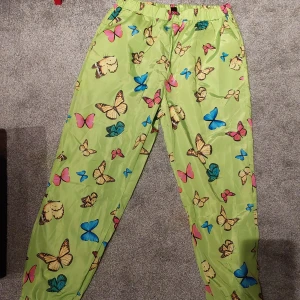 Coola brallor;) - Snygga och bekväma byxor i strlk L. Känns lite som regnbyxor i materialet. Neongröna typ.  Djur finns i hemmet.
