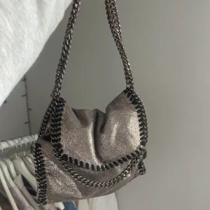 väska  - Jättefin väska som säljs i hopp om att någon annan får mer användning för den. Lite rostfärgad vid banden men inget som man lägger märke till. Fin glittrig grå färg. Säljs till högst bud 💛På bilderna har jag vikt bandet. 