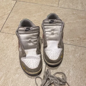 Nike dunk low - Jag har ett par Nike dunk low som jag inte använder längre. Dom är inte i så bra skick där dom är smutsiga och har två små hål där fram.