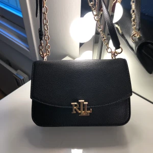 Ralph lauren  - Säljer min Ralph lauren väska, köpt för 2700 på jonhells.  Den är lite Rostig vid kedjorna och Rh märket men fortfarande användbar och fin, Man kan både ha den som axelväska och en långväska🖤