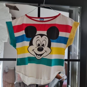 Vintage Disney T-shirt, märkt Made i USA, Walt Disney Productions. 1980/90-tal - Vintage T-shirt från 1980/90-talet i fint skick. Musse Pigg-tryck. Märkt Walt Disney Productions Made in U.S.A. Strl märkt Large men är mer en XS/S. 