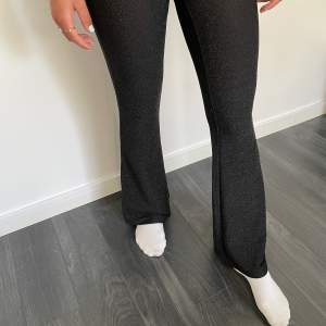 Svarta glittriga byxor/leggings med bootcut från Gina Tricot.  Personen på bilden är 168cm lång och bär strl S