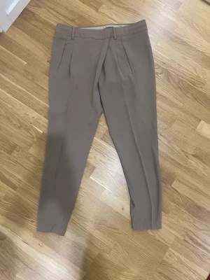 Vince beiga finbyxor med läderdetaljer stl 34 - Jätte fina i jätte bra skick finbyxor från märket Vince sitter jätte bra på med skindetaljer vid fickorna i stl US 2 vilket motsvarar stl 34