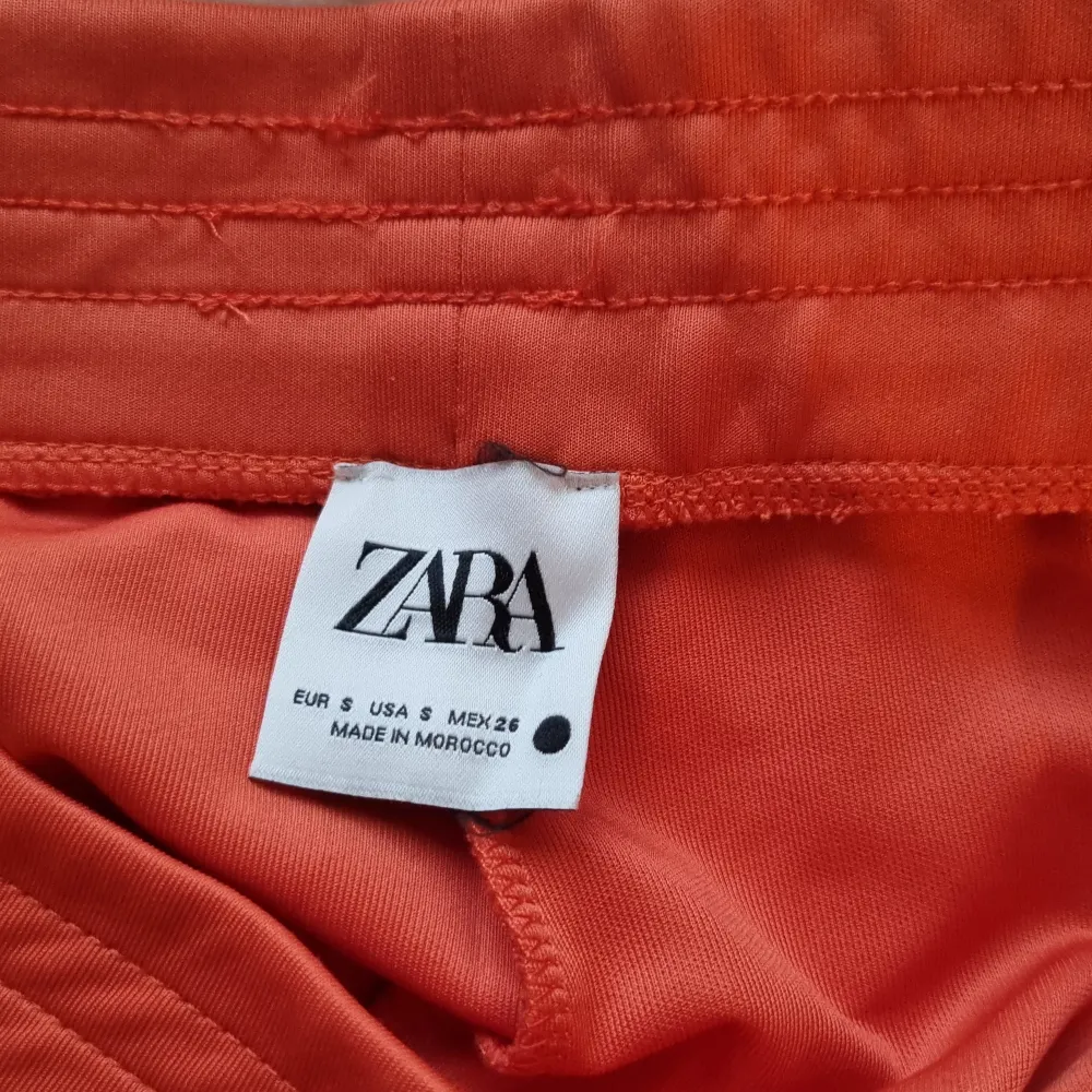 Orangea byxor från Zara i strl S. Aldrig använda. Köparen står för frakt. . Jeans & Byxor.