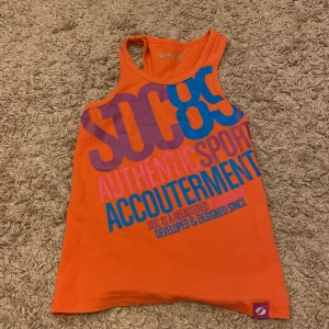 Ett rosa linne - Det är ett rosa linne med text i blå lilla och en starkare rosa 