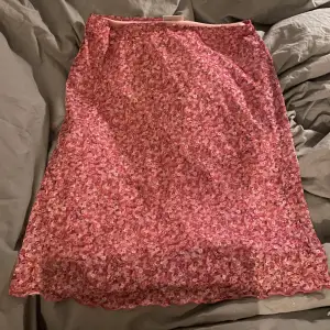 söt rosa kjol med blommönster 🙏 den är i storlek XL men skulle säga att den passar M-XL beroende på hur man vill att den ska sitta 🫶