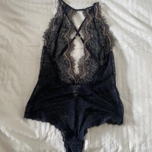 Spetsbody gulddetaljer, string - Säljer en spetsbody med gulddetaljer i stringmodell. Låg i ryggen och korsad. Reglerbara axelband. Fint skick, knappt använd. Passar small och medium