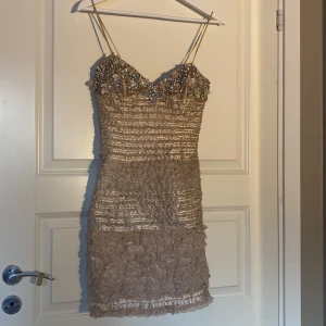Fest klänning - Kost festklänning. Mycket glitter och paljetter. Textur, blommor och stenar. Storlek XS.