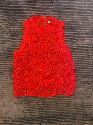 Spets topp - Röd spelstopp med dragkedja i strl S säljer för 65kr