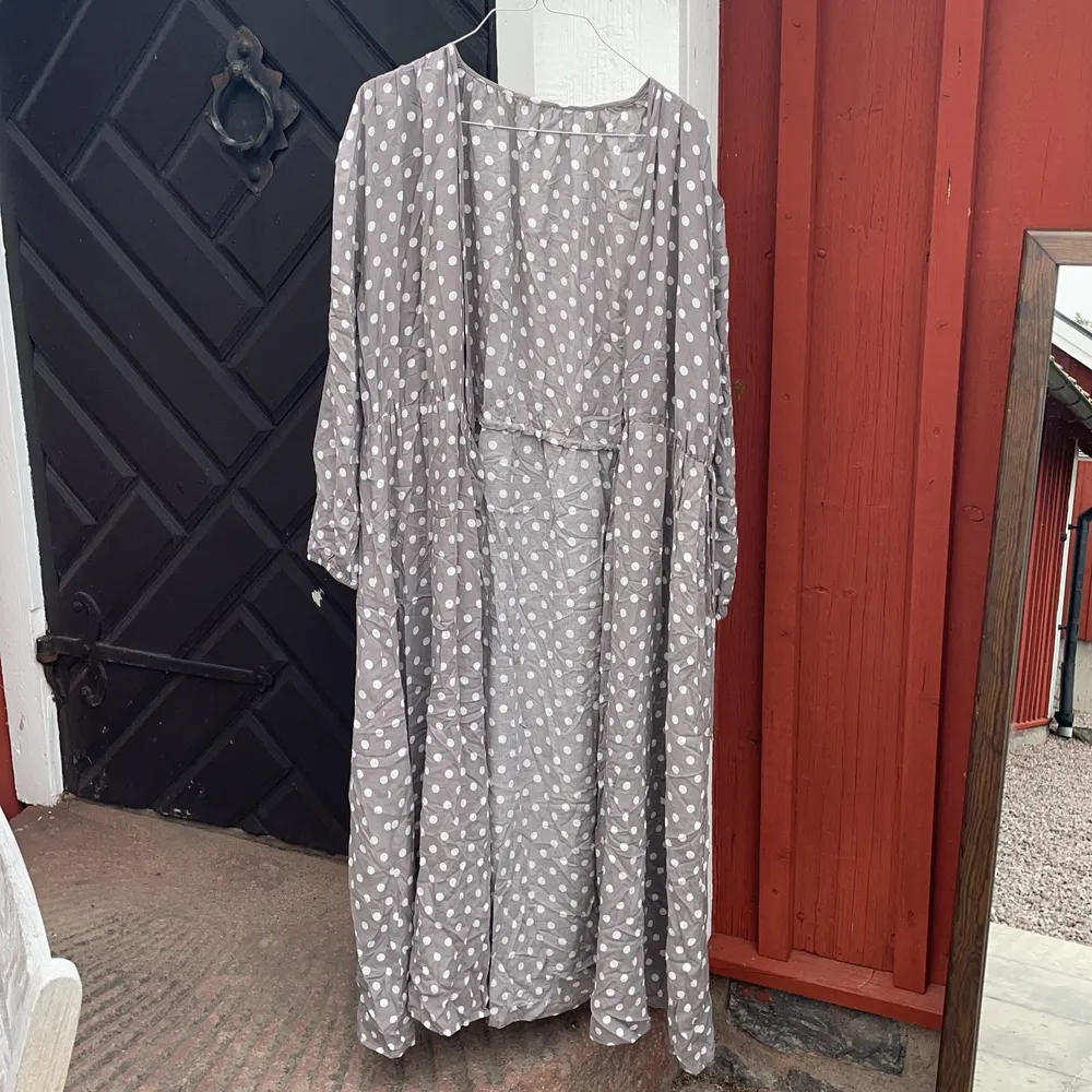 En grå klänning med prickar från okänt märke. Kan även användas som en tunn kappa . Klänningar.