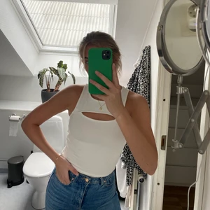 Vitt linne - Vitt tight ribbat linne med urringning både fram- och baktill, från Gina Tricot i storlek XS.