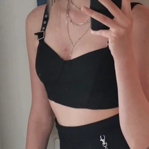 Svart topp - En svart stretchig topp från HM (Divided) med ställbara axelband och ”korsettliknande” detaljer 🤪 Säljer då den inte passar 😙 I nyskick 🪸🌞