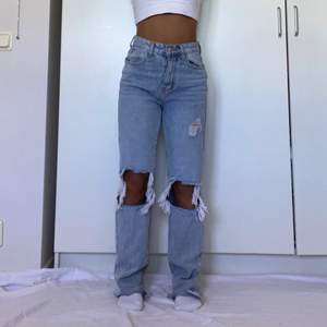 Blå ripped jeans med hög midja. Raka / straight leg i modellen. För referens ä jag 160 cm (dess är för långa för mig) och midjemått ca 65-70cm. Jag har oftast stl 36 i jeans. Enda defekten är att det är lite fläckar längst ner på ena benet (se bild 3)