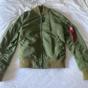 Alpha jacka S - Säljer min alpha jacka då den bara hänger den är använd rätt mycket så drf finns små skavanker, den svarta fläcken på baksidan vet jag inte vad de är o får inte bort den, finns även ett hål i innerfickan. O muddarna är lite solblekta.