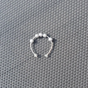Stressreducerande ring - Justerbar stressreducerande ring i silver. De tre översta pärlorna är lösa med syfte att leka med i stressande situationer. 10% av kostnaden går till organisationen Mind! 💓