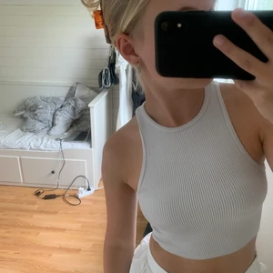 ribbat linne  - Ett vitt tajt sittande ribbat linne som är cropat i modellen sitter super snyggt på kroppen och är i jätte skönt material 