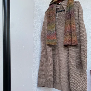 Kofta  - Stickad lång kofta med fickor på sidorna. Har långa ärmar.