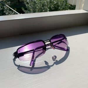 Solglasögon, Lila med fade i glaset  - Lila solglasögon, en pytteliten spricka uppe i hörnet på högra glaset men det stör inte synen.  Köpare betalar frakt.