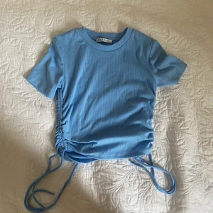 Blå topp - Fin blå topp från Zara med detaljer på sidorna. Har inte används mycket. Fint skick. 