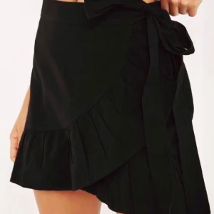 En svart omlott kjol - En svart omlott kjol🍂Endas används några gånger,Sitter förtajt i midjan den har resor i back👍🏻Frågor eller funderingar skriv här eller privat🤍✨